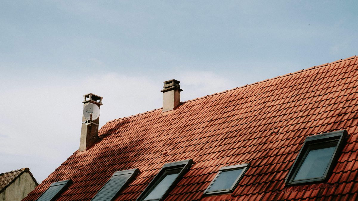 Vibrant Red Roof with Windows and Chimneys - Roof Ventilation